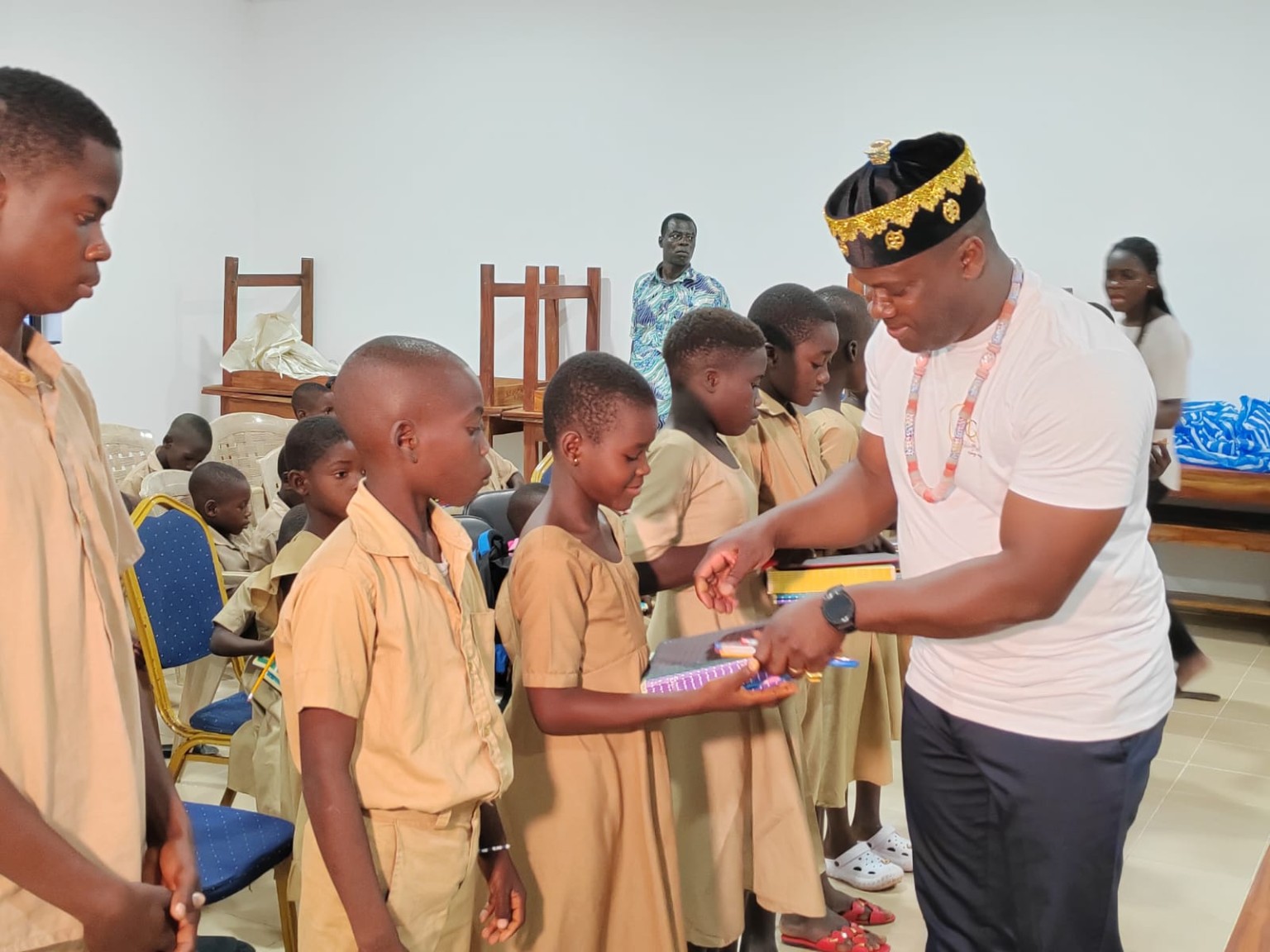 Remise de cahiers et de stylos à une élève au Togo